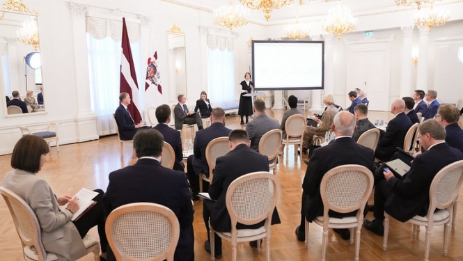 Sanāksmju zāle ar cilvēkiem, kuri klausās viedās administrācijas un reģionālās attīstības ministres uzrunu