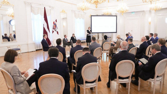 Sanāksmju zāle ar cilvēkiem, kuri klausās viedās administrācijas un reģionālās attīstības ministres uzrunu